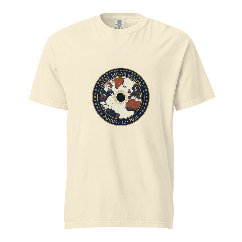 Model wearing ivory Comfort Colors t-shirt with circular vintage mission-patch graphic showing the August 12 2026 total solar eclipse path from Greenland through Iceland to northern Spain, gold star border on navy ring, white corona eclipse disc at center